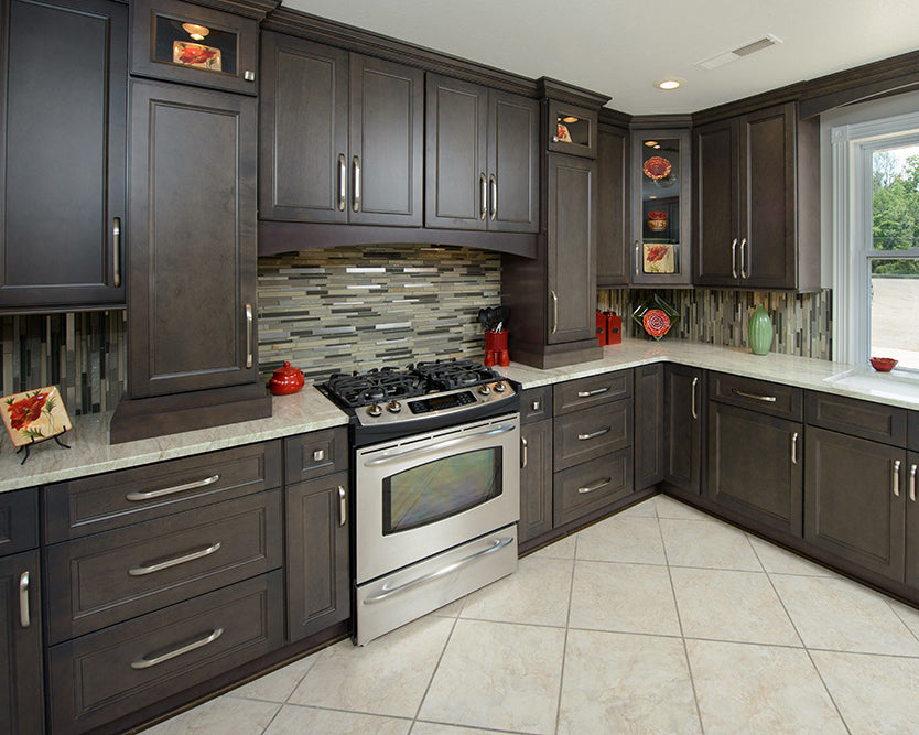 Modern kitchen with dark wood cabinets, stainless steel appliances, and a tiled backsplash.